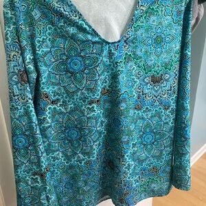 Cute stylish top with beautiful turquoise colors but too snug in my breast .